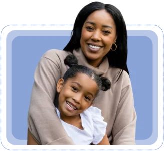 Smiling mother hugging her young daughter, representing family connection and support.