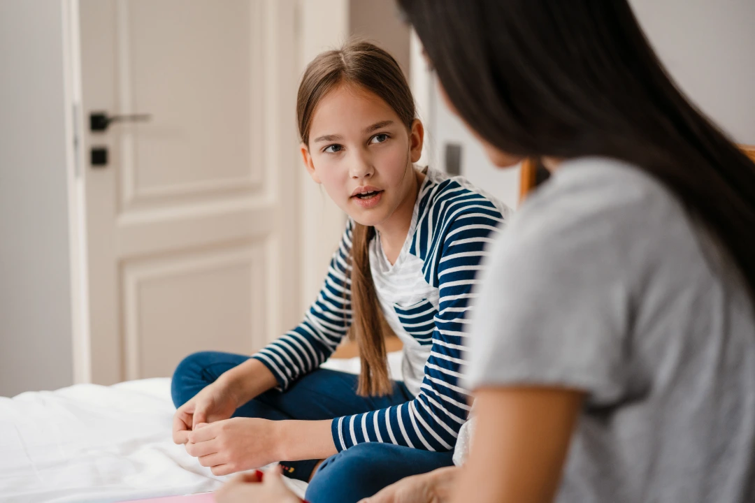 Parent and child sitting together during a coaching session, engaging in calm, supportive conversation.