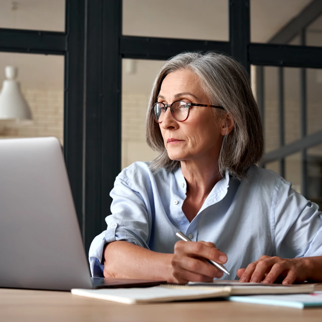Caregiver attentively engaging in a virtual or in-person training session with notes at their desk, representing the TBRI® (Trust-Based Relational Intervention) caregiver training at ConnectionPlus Care.