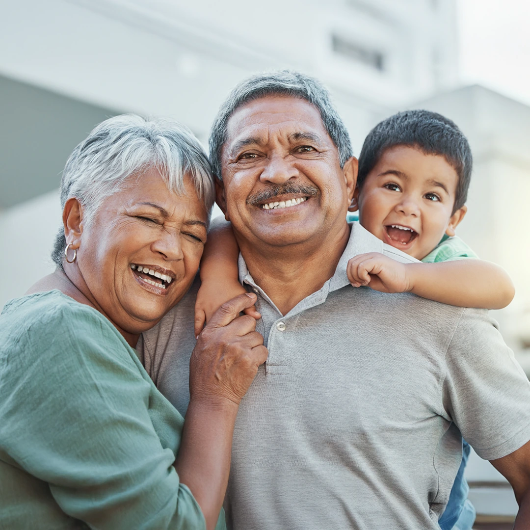 Older adults embracing a child outdoors, symbolizing trust-based relationships and family connection.