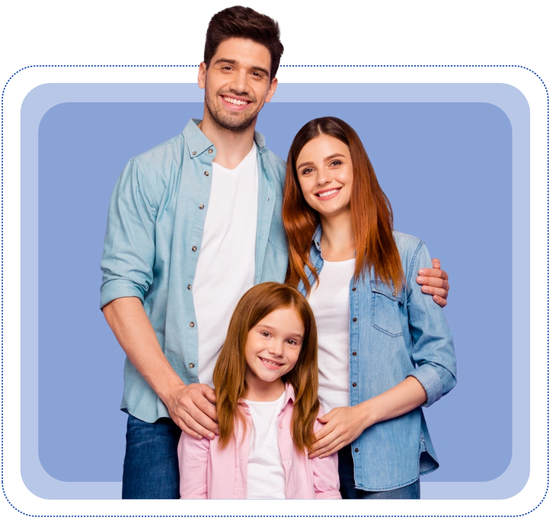 Smiling family of three—father, mother and young daughter—standing closely together against a blue backdrop.