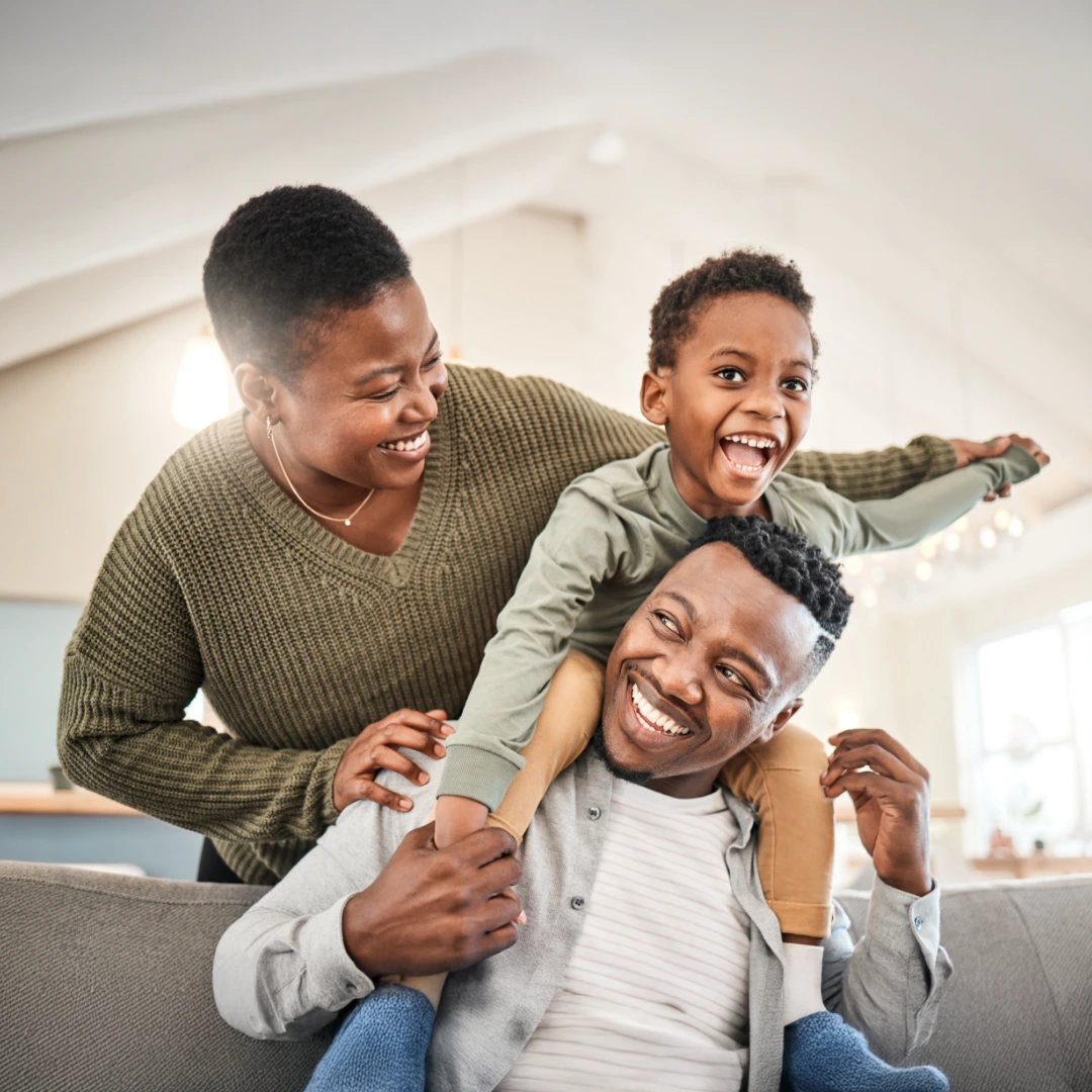 Smiling caregiver embraces a child outdoors as they walk together in soft daylight, symbolizing support, connection, and healing.